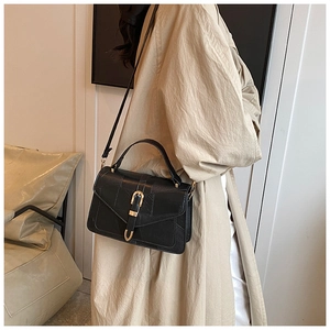 Détail du sac bandoulière noir en similicuir crocodile avec fermoir élégant en métal doré