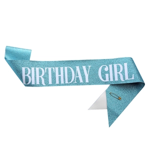 Détail de l'écharpe d'anniversaire bleue pailletée avec texte blanc et épingle