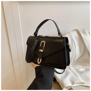 Détail du sac à main noir en similicuir texturé avec boucle métallique dorée en forme de U