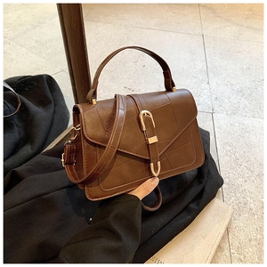 Détail du sac bandoulière vintage marron foncé en cuir texturé avec boucle en métal doré