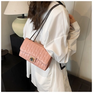Detailed view of pink quilted leather bag with floral twist lock and metal chain strap