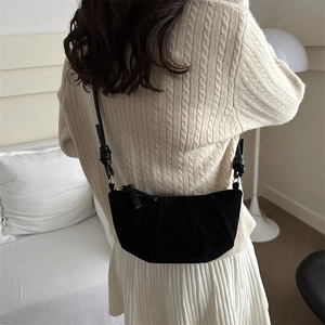 Sac bandoulière demi-lune noir en daim avec design plissé et détails de nœuds élégants