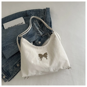 Detail of white pleated shoulder bag with butterfly metal buckle and soft cloud texture