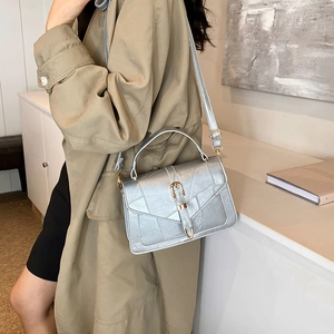 Sac bandoulière argenté avec coutures géométriques et boucle métallique dorée en U