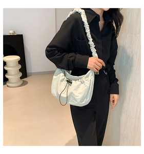 Detail view of cream nylon shoulder bag with scrunchie strap and adjustable drawstrings