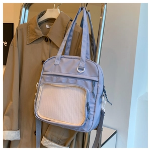 Détail du sac fourre-tout en nylon lilas avec poche avant en filet et bandoulière réglable