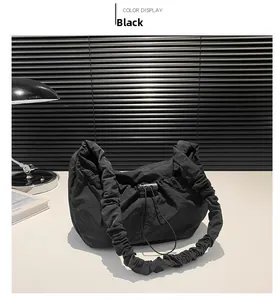 Detail view of black drawstring nylon shoulder bag with stylish ruched elastic strap