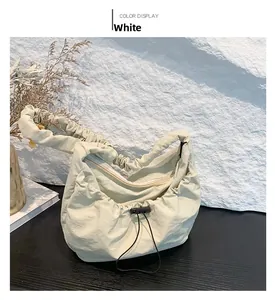 Close-up of white pleated nylon shoulder bag with adjustable drawstring and zipper detail