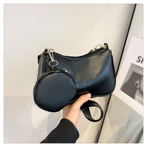 Detail of black PU leather half-moon shoulder bag with detachable round coin purse and gold hardware