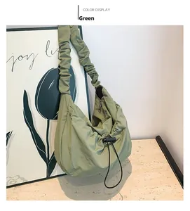 Close-up of light green drawstring nylon shoulder bag with ruched strap detail