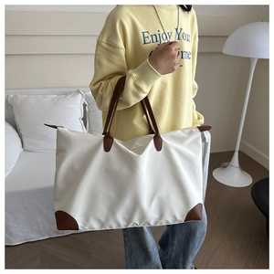 Borsa da viaggio bianca in nylon con manici in pelle marrone in un interno