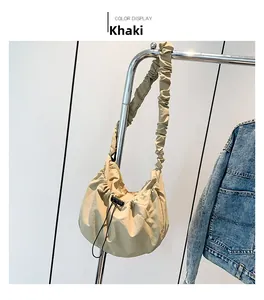 Detail of khaki nylon pleated cloud bag with drawstring closure and stylish strap