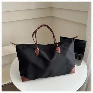 Detail of waterproof Oxford tote with leather handles and laptop in a lifestyle setting