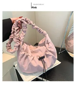 Detail view of pink pleated nylon underarm bag featuring a drawstring closure and ruffled handle