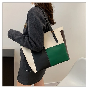 Lifestyle view of large color-block tote bag showing geometric leather patches and strap