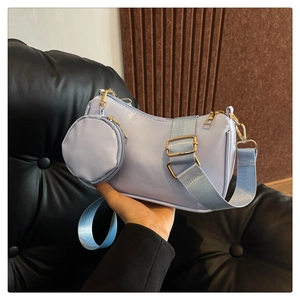 Detail of light blue two-in-one shoulder bag with round coin purse and gold hardware
