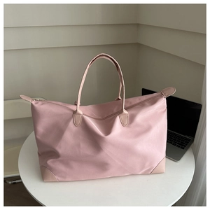 Detail of light pink waterproof oxford tote bag showing durable nylon texture and zippers