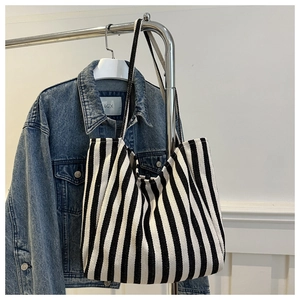 Detailed macro view of the thick canvas texture and black vertical stripes of the tote bag