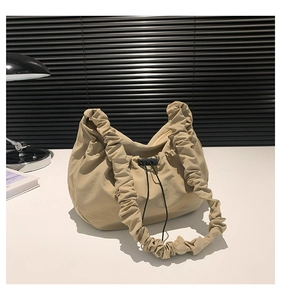 Detailed view of beige pleated nylon tote bag with drawstring buckle and soft texture