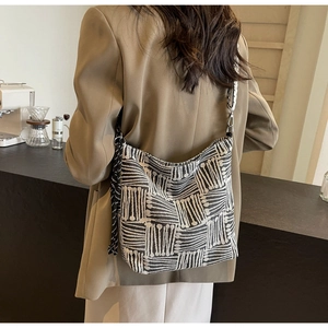 Detailed back view of large black and white geometric canvas tote with woven tassel and strap