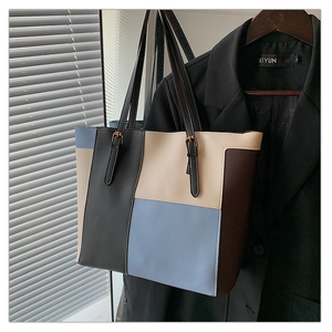 Detail view of contrast color stitching and adjustable silver buckle on large tote bag strap