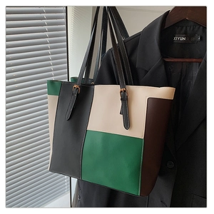 Detail of multi-color patchwork leather tote bag with adjustable black straps and gold buckles