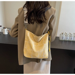 Detail of yellow geometric knit tote bag with checkerboard strap and woven texture