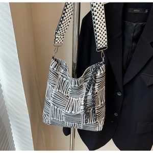 Detail of checkered canvas tote bag with woven jacquard pattern and wide shoulder strap