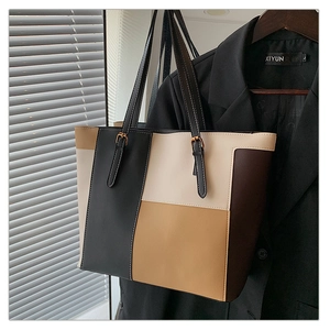 Detail view of the stitching and adjustable buckle on this contrast color tote bag