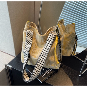 Close-up of yellow checkered canvas tote bag with adjustable houndstooth wide strap
