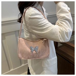 Close-up of pink satin shoulder bag featuring a silver metal butterfly ornament