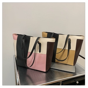 Detail view of two large color-block tote bags in vintage PU leather with long handles