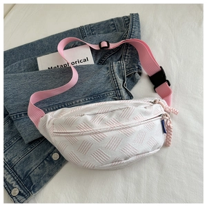 Detail of pink geometric woven crossbody bag with durable nylon strap and plastic buckle