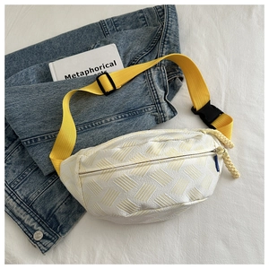 Detail of woven fabric chest bag with yellow nylon strap on a lifestyle background