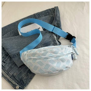 Detail of blue geometric stripe woven texture on a white nylon crossbody waist bag