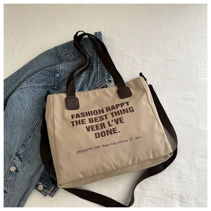 Détail du sac cabas en toile avec imprimé lettres et bandoulière réglable chic