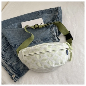 Close-up of white chest bag featuring green geometric stripes and olive nylon strap