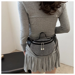 Close-up of black rhinestone waist bag with pearl zipper detail on model back view