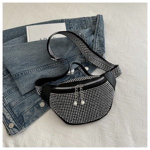 Detail of studded waist bag with pearl zipper and wide herringbone shoulder strap