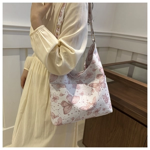 Close-up of butterfly print tote bag with metallic rivets and shoulder strap details