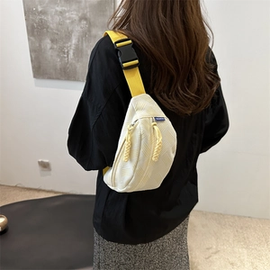 Chic cream crossbody chest bag with quilted texture and vibrant yellow nylon strap