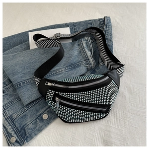 Detail of black waist bag featuring light blue rhinestones and patterned wide strap