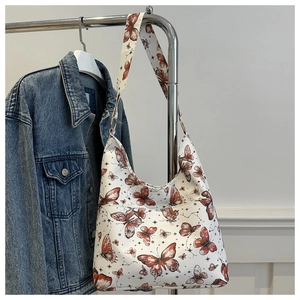 Detail of bohemian butterfly print on white faux leather hobo bag hanging on a rack
