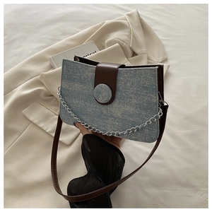 Detail of light blue denim crossbody bag with silver chain and white glitter sparkles
