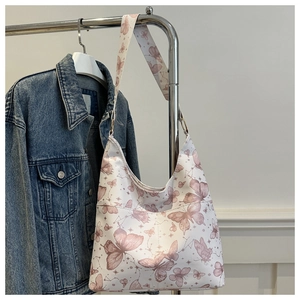 Detail of pink butterfly print on white shoulder bag with a wide matching strap