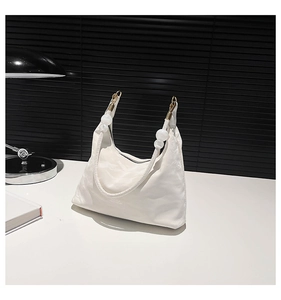 Detail view of the white fabric shoulder bag with Classic text and gold metal accents