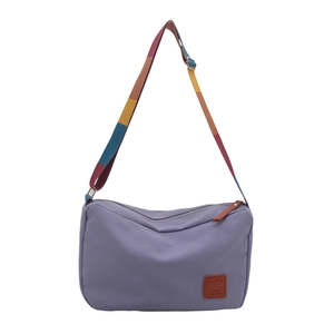 Minimalist lavender canvas crossbody bag featuring vibrant colorful striped shoulder strap