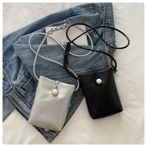 Détail de mini sacs bandoulière en cuir argenté et noir avec boucle en perle ronde