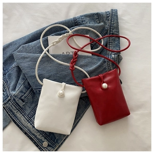 Détail de mini sacs bandoulière élégants avec gros bouton perle et bandoulière tressée