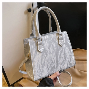 Detailed macro of silver pleated texture and gold hardware on this chic PU crossbody bag
